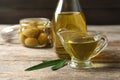 Gravy boat with fresh olive oil on wooden table Royalty Free Stock Photo