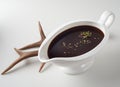 Gravy boat with Worcestershire sauce served on table with roots