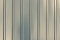 Gray abstract background with stripes. Metallic striped surface. Gold metalline wall siding, cladding. Striated grey shiny fence w Royalty Free Stock Photo