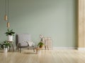 Gray armchair with table on light green wall and wooden flooring Royalty Free Stock Photo
