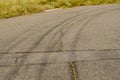 Gray asphalt with black tire tracks. An old country road with cr Royalty Free Stock Photo