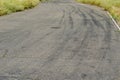 Gray asphalt with black tire tracks. An old country road with cr Royalty Free Stock Photo