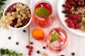 On a gray background, a blurred image of fruit drinks with ice cubes and fruits in a bowl.