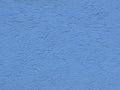 Gray background facade plaster . Monolithic plaster decorative backdrop. Single layer scraped cement plaster wallpaper. Blue exter