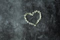 Gray background marble gloomy cement floor. Symbol heart laid out with flowers. The figure of the heart is lined with flowering Royalty Free Stock Photo