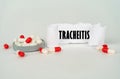On a gray background, medical capsules and a paper plate with the inscription - Tracheitis