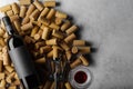 On a gray background there are a lot of wine corks, a bottle of red wine, a corkscrew and a glass. Low angle view. Restaurant, Royalty Free Stock Photo