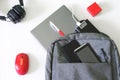 Gray backpack, laptop, power bank, two mobile phones, headphones, mouse, pen and red gift box on a white background. Travel, trip Royalty Free Stock Photo