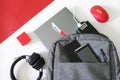 Gray backpack, laptop, two mobile smartphones, headphones, computer mouse, pen, red gift box and  power bank, on a white backgroun Royalty Free Stock Photo