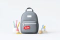 Gray backpack with sale tag and stationery on white background Royalty Free Stock Photo