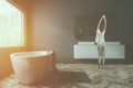 Gray bathroom, tub and sink, side view, woman Royalty Free Stock Photo