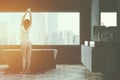 Gray bathroom with tub and sink, woman Royalty Free Stock Photo