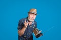 Gray bearded eldery man expressively rise his finger. Gentleman in straw hat holding old portable radio with antenna looking to Royalty Free Stock Photo