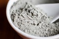 Gray bentonite clay powder in a bowl. Diy facial mask and body wrap recipe. Natural beauty treatment and spa. Clay texture closeup Royalty Free Stock Photo