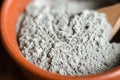 Gray bentonite clay powder in a bowl. Diy facial mask and body wrap recipe. Natural beauty treatment and spa. Clay texture closeup Royalty Free Stock Photo