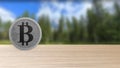 Gray bitcoin silver coin on wood wooden table over forest trees blur. bit-coin 3d render isolated, cryptocurrency, crypto,