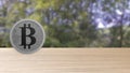 Gray bitcoin silver coin on wood wooden table over forest trees blur. bit-coin 3d render isolated, cryptocurrency, crypto,