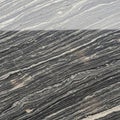 Gray and black banded rock surface displaying a striking pattern of undulating, parall Royalty Free Stock Photo
