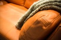 Gray blanket draped over a leather couch