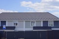 Gray blue private house with windows under a  tiled roof behind a metal fence Royalty Free Stock Photo