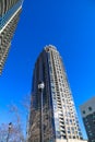 A gray and blue skyscraper and office buildings with metal balconies with tall black light posts and bare winter trees Royalty Free Stock Photo