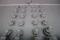 Gray bolts with thread with screwed nuts on the metal panel Royalty Free Stock Photo