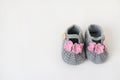 Gray booties for girls with pink flowers and a wooden button on a white background Royalty Free Stock Photo