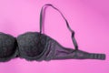 Gray bra on a pink background top view.