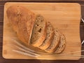 Gray bread with grains on a wooden board and ears