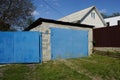 Gray brick garage with blue iron gates