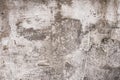 Gray and brown shabby concrete wall with flaky plaster. Torn rough old cement wall texture, background. Vintage, natural cracked d