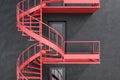 Gray building with red spiral fire escape stairs Royalty Free Stock Photo