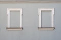 Gray building wall with 2 window frames placeholders bricked up.  Being in isolation; hidden, silent and secured area. Royalty Free Stock Photo