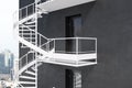 Gray building with white spiral fire escape stairs Royalty Free Stock Photo