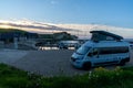 Gray camper van parked at a small harbor in northern Denmark at sunset