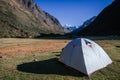 gray camping tent with high snowy mountains in the background, on the trekking of the quebrada santa cruz