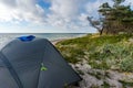 Gray camping tent on the sea. Camping on the beach. Recreation of nature with tents