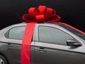 Gray car with red ribbon on black Royalty Free Stock Photo