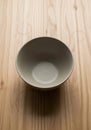 A gray ceramic bowl sits on a light wood surface, featuring prominent grai Royalty Free Stock Photo