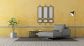 Gray chaise lounge om old yellow wall Royalty Free Stock Photo