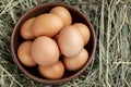 Gray chicken eggs in a clay bowl on a background of hay Royalty Free Stock Photo