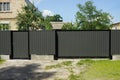 Gray closed metal gate and door with part of the fence Royalty Free Stock Photo