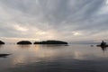Gray cloudy sky over calm lake. Islands on the horizon. Vacation and travel concept