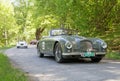 Gray color Aston Martin DB2 dhc classic car from 1952 driving on a country road