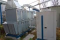 Gray commercial ventilation unit with big condensing unit standing outdoor on the ground covered by fallen leaves