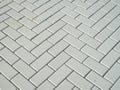 Gray concrete block pavement in herringbone pattern on sidewalk closeup Royalty Free Stock Photo
