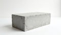 Gray concrete brick on white surface with rough texture, uneven edges. Single, rectangular, three-dimensional object. Industrial, Royalty Free Stock Photo