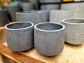 gray concrete flower pots, lined up in a warehouse in rows for sale.