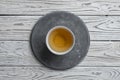 Gray concrete round plate on light wooden background and a Cup of tea