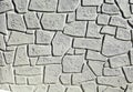 Gray concrete wall with forms of fake decorative rocks carved on the surface.